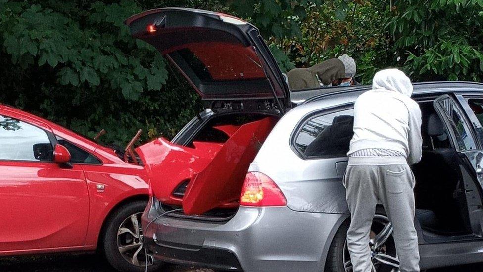 A gang stealing parts from a red Vauxhall Corsa in Birmingham