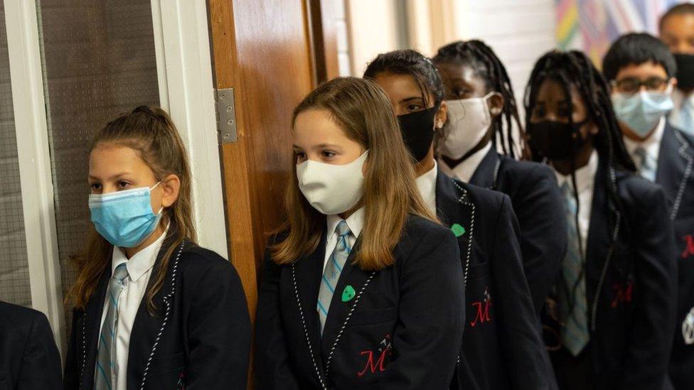 Year eight pupils wear face masks as a precaution against the transmission of the novel coronavirus as they queue in a corridor before attending an English lesson at Moor End Academy in Huddersfield