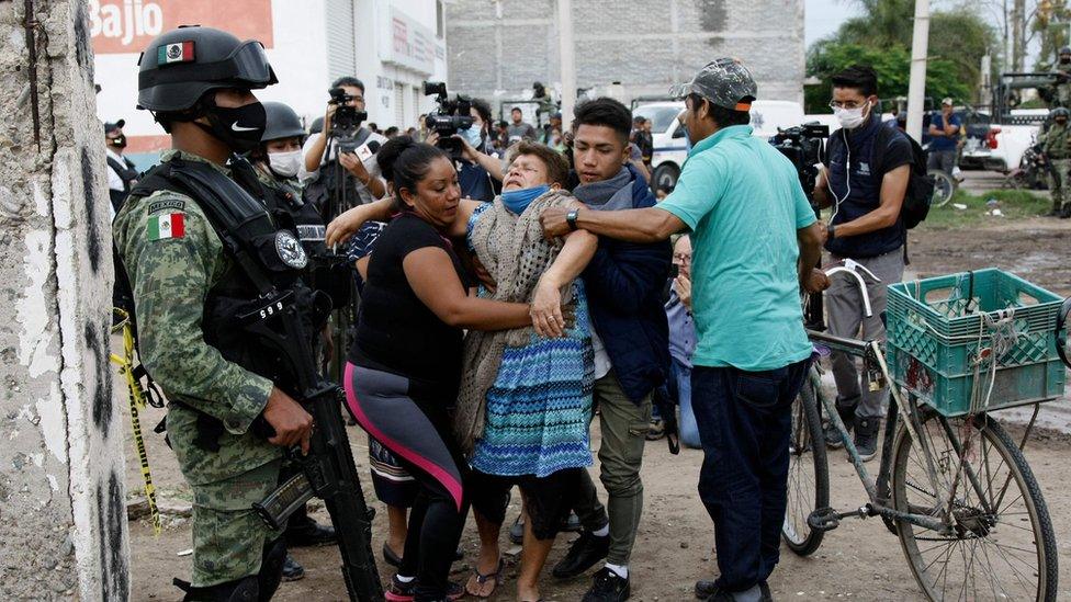 A woman reacts near the crime scene where 24 people were killed in Irapuato, Guanajuato state, Mexico, on July 1, 2020.