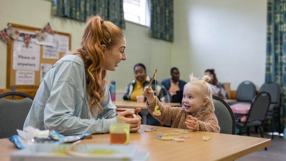 A mum and her young daughter playing together at a community centre