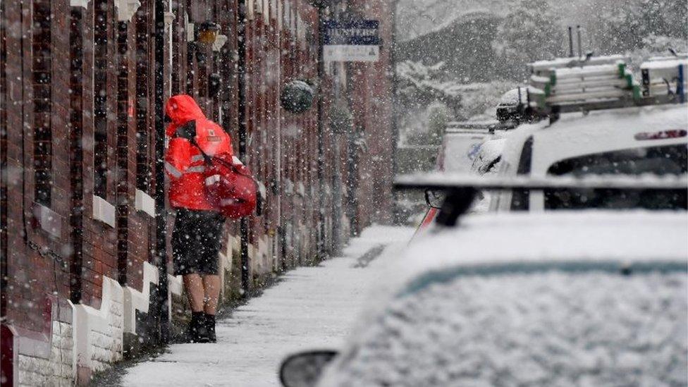 Postman making deliveries in Stalybridge, Greater Manchester