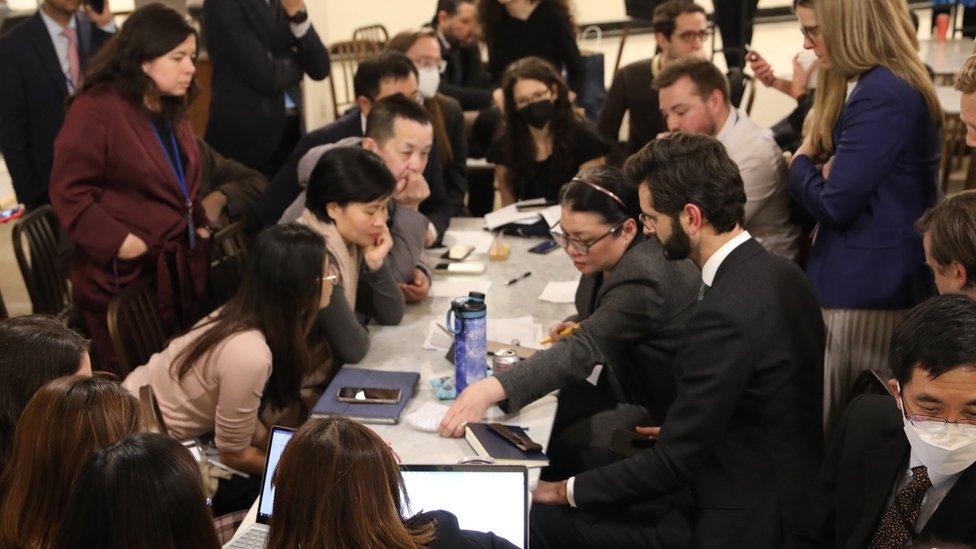 President Rena Lee discusses the oceans treaty with other delegates sat around a lot table with tens of people surrounding