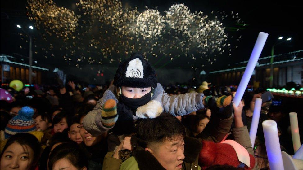 Revellers watch as a fireworks display marks the arrival of the new year following a countdown event on Kim Il Sung Square in Pyongyang on January 1, 2019