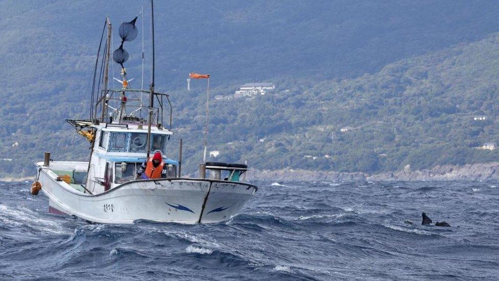 Japanese boat near a piece of wreckage believed to be from the Osprey