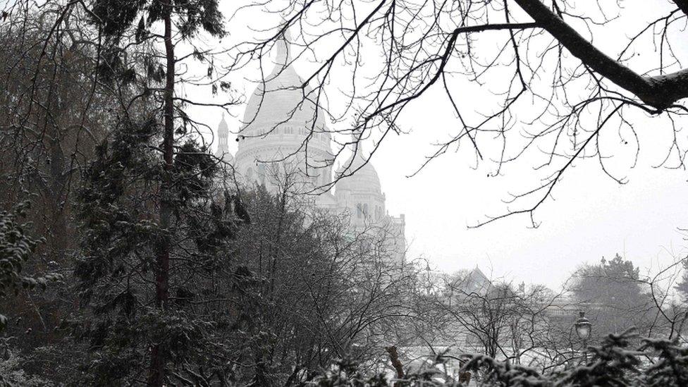 Snow-covered trees are seen near the Sacré Coeur in Paris during heavy snow falls on 22 January 2019