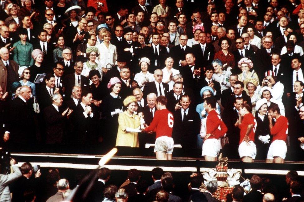 England captain Bobby Moore holds the Jules Rimet Trophy, collected from the Queen, after leading his team to a 4-2 victory over West Germany in the World Cup Final that went to extra time at Wembley, London