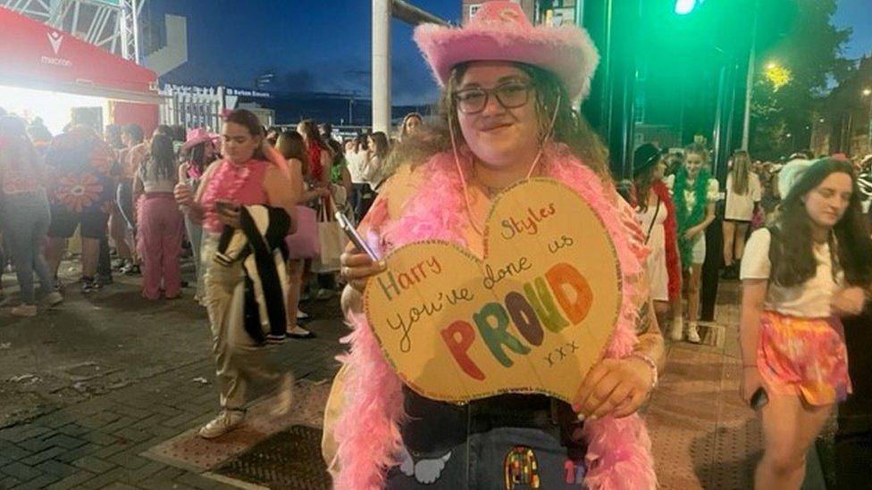 Meg Jones in the crown holding a Harry you've done up proud sign