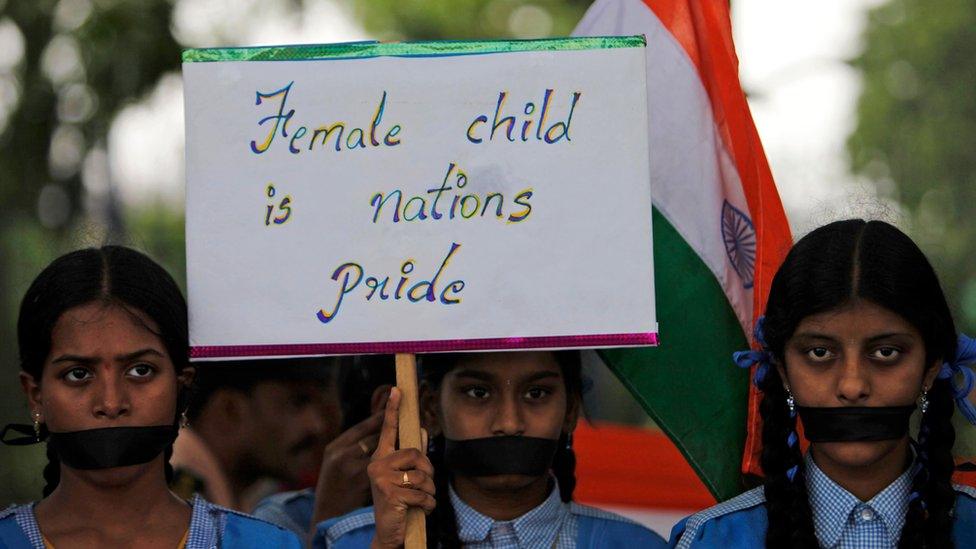 Indian schoolgirls hold a placard and participate in a silent rally against the rape of a 5-year-old girl in New Delhi, in Hyderabad, India, Tuesday, April 23, 2013