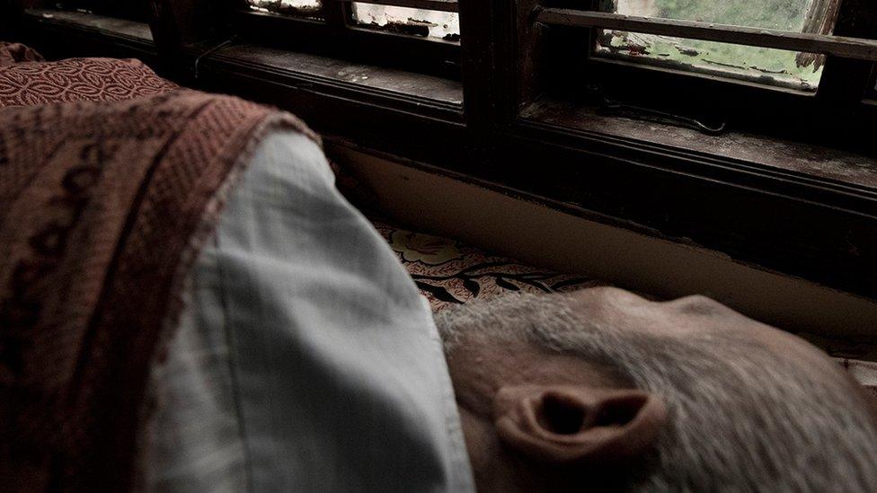 Mr Nagaraj lying down on his bed in the care home