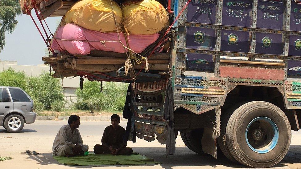 Boys seek refuge from the heat of the August sun