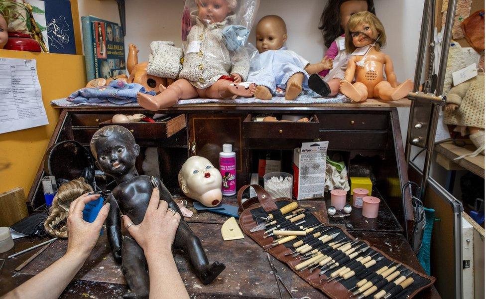 Inside the toy hospital, someone is repairing an old doll