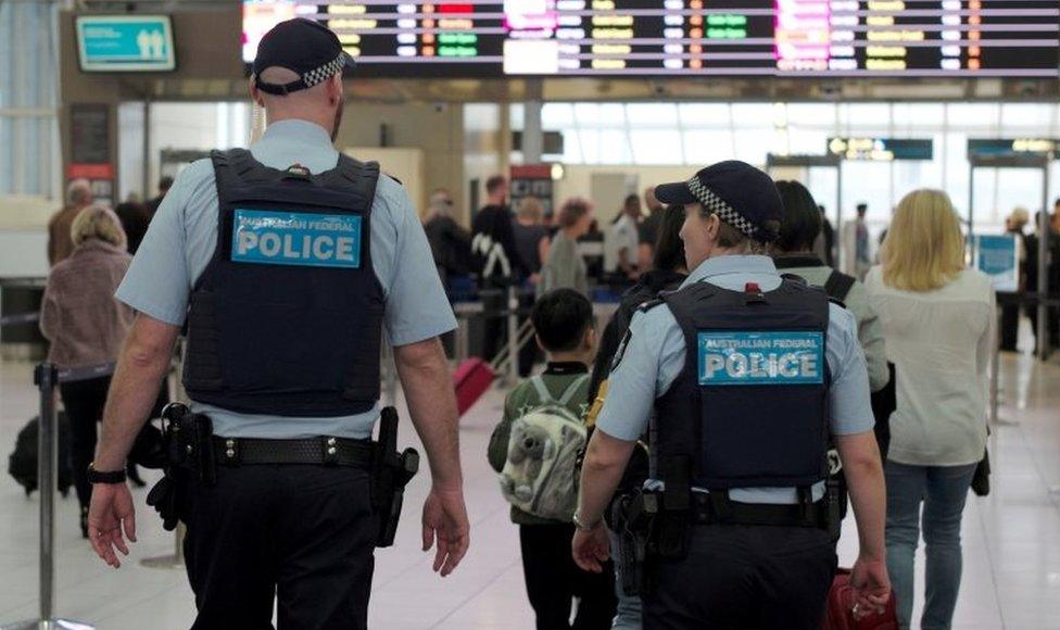 Two Australian Federal Police officers walk through Sydney Airport