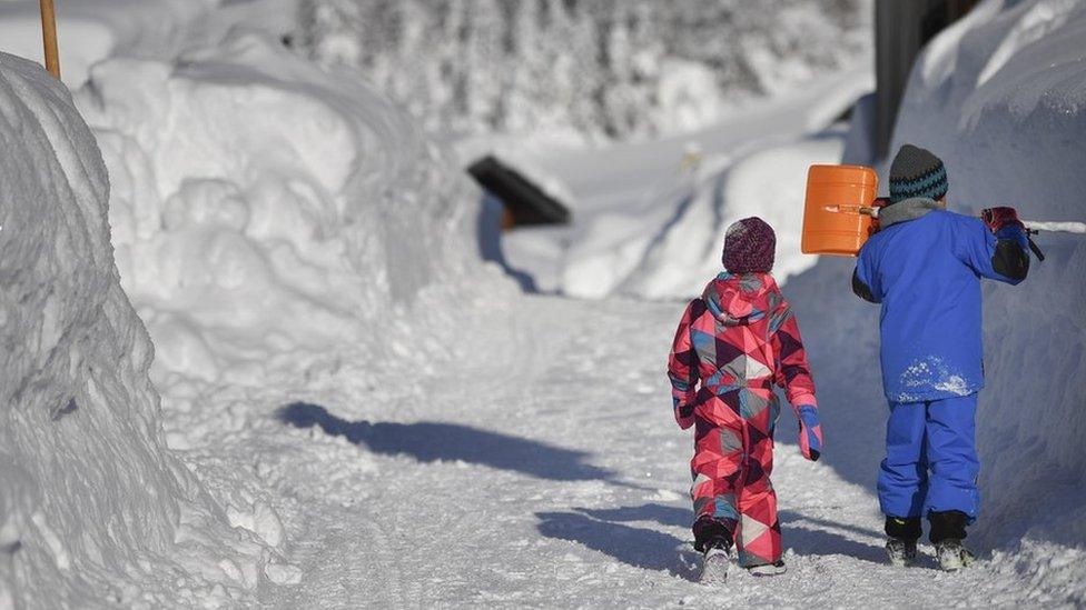 Children walk along a snow covered road in Gerold, Germany, 11 January 2019