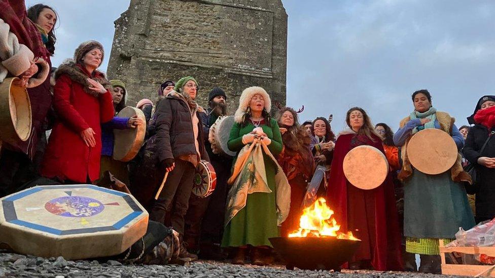 People celebrating winter solstice at Glastonbury Tor