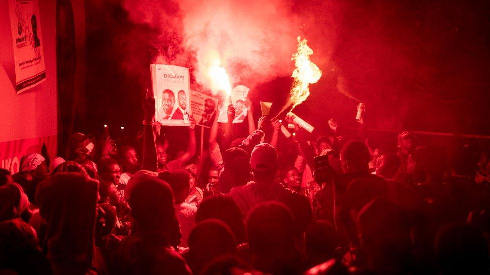 Supporters of opposition presidential candidate Bassirou Diomaye Faye and opposition leader Ousmane Sonko celebrate at Diomaye's coalition headquarters as the votes are being counted in Dakar, on March 24, 2024