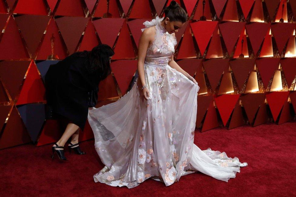 Actor Hailee Steinfeld adjusts her dress on the red carpet