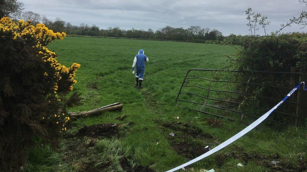 Forensic officer inspects a field near where thieves attempted to steal a cash machine