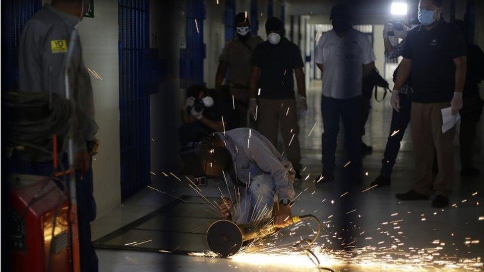 Workers of the Izalco Penitentiary Complex work on the installation of a metal plate in each cell of the prison in Izalco, El Salvador, 27 April 2020.