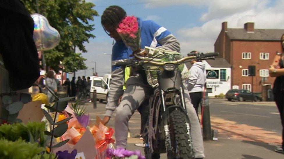 A mourner at the scene of a fatal crash