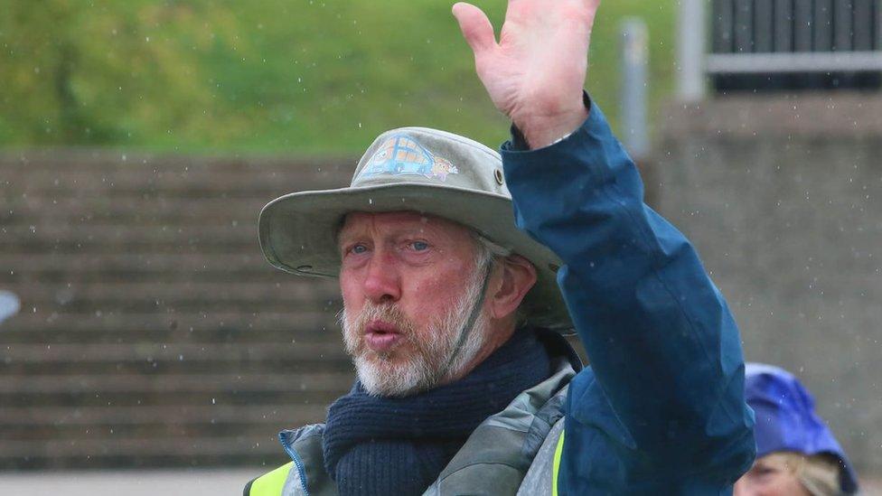 Brian Burnie waves as he completes walk