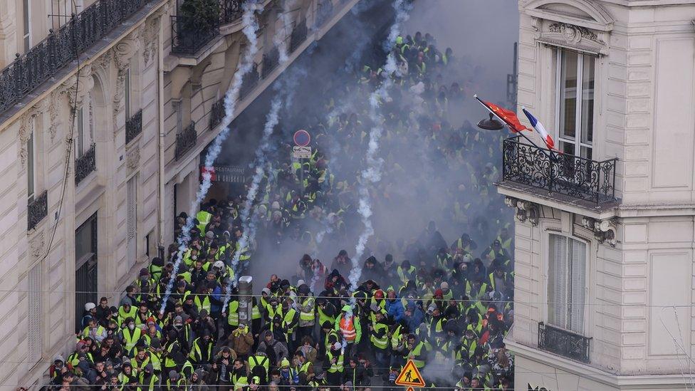 Protesters flee as the police in Paris fire tear gas