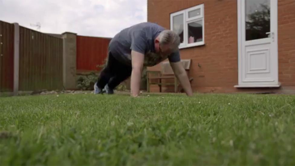 Man doing press up in back garden