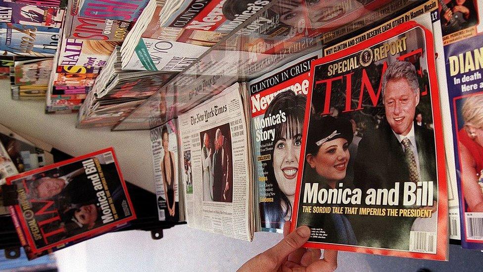 A woman reaches for a copy of Time Magazine on a news stand 26 January in New York, NY.