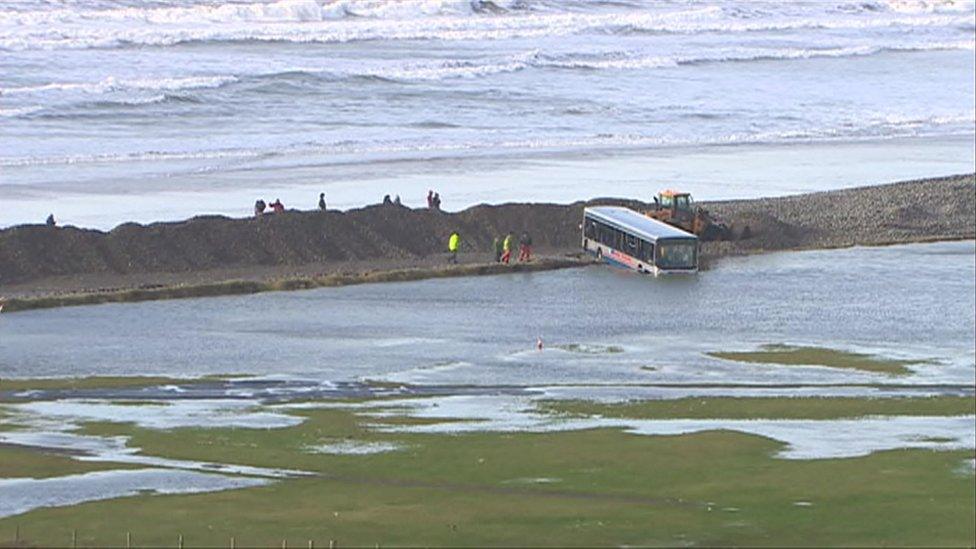 A bus lies partially submerged in water after Newgale is battered by storms in 2014