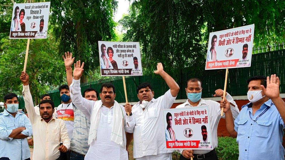 Supporters of India's Congress party hold placards and shout slogans as they demand party's president to be from the Gandhi family and leader Sonia Gandhi should continue as interim Congress president, outside the party headquarters in New Delhi on August 24, 2020.