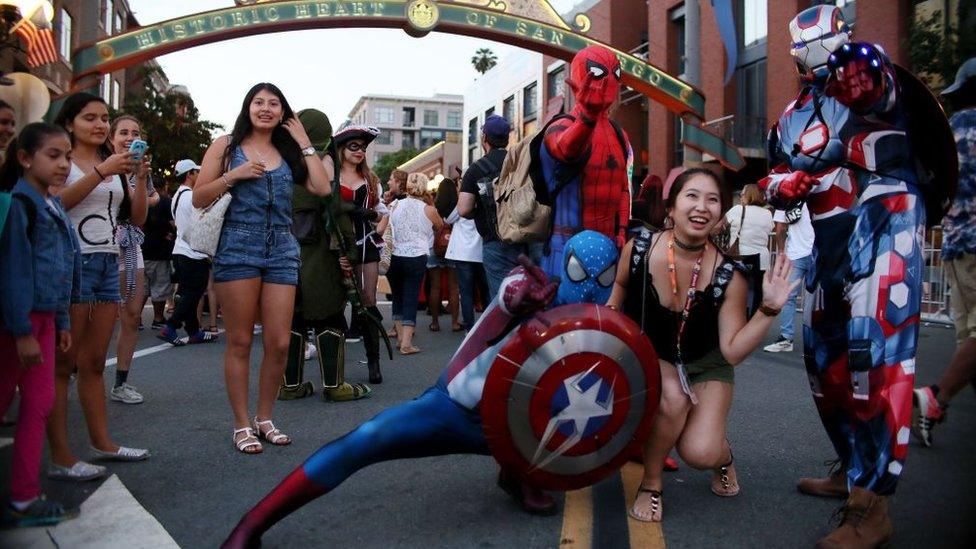 Cosplay characters pose for pictures along 5th Avenue in the Gaslamp Quarter during Comic Con International on July 20, 2017 in San Diego, California