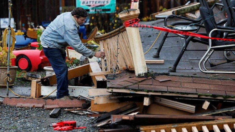 A man inspects a damaged building