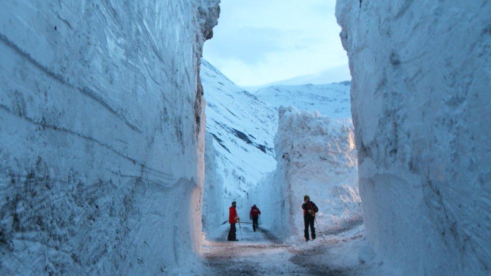 Workers cut through snow wall on the Bessans to Bonneval-sur-Arc road in France