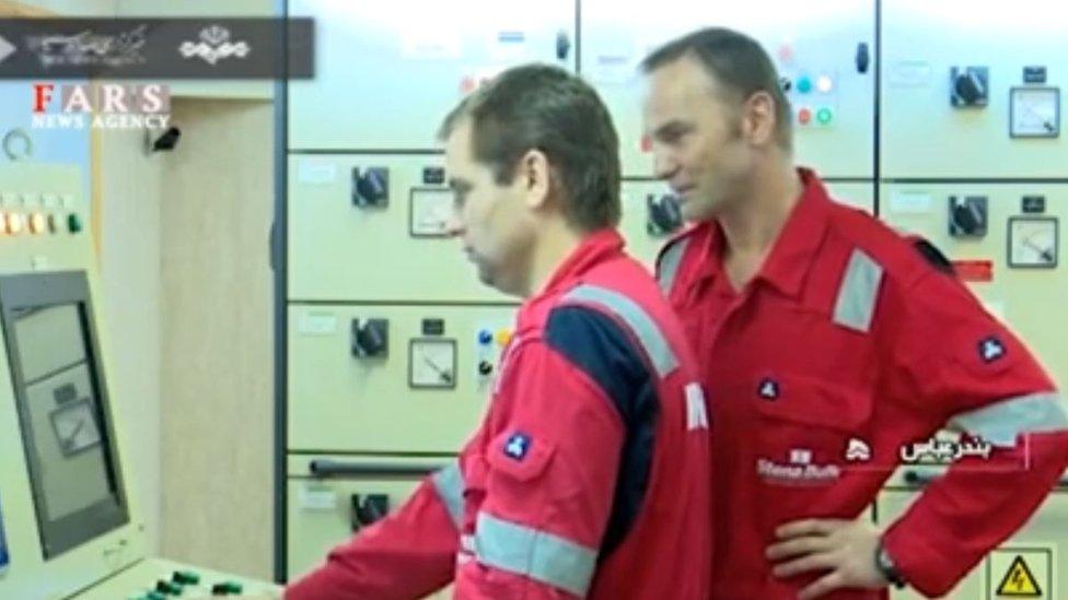 Crew members monitor computers onboard the tanker