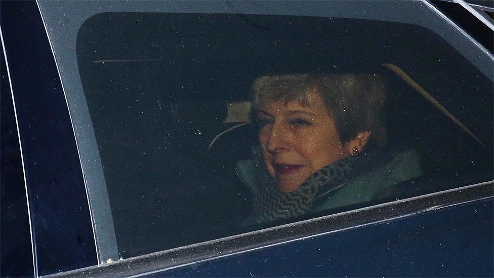 Theresa May seen leaving Parliament through a car window on 27 March