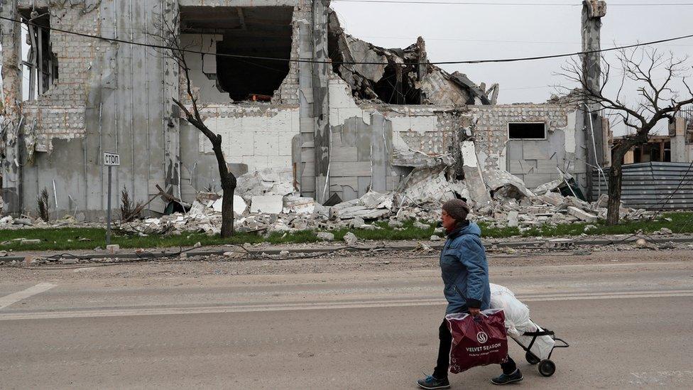 A civilian walks through Mariupol