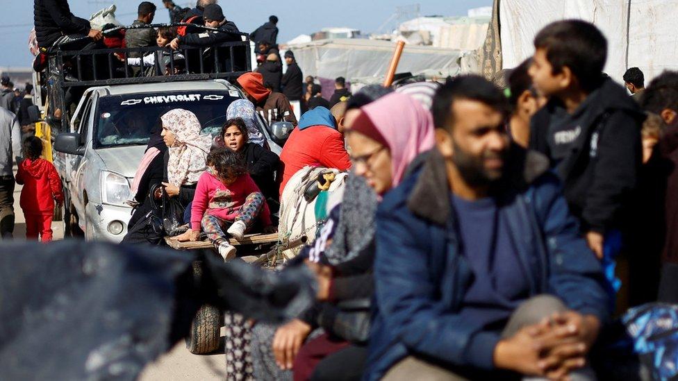 Palestinians flee the city of Khan Younis on pick-up trucks and horse-drawn carts amid intense fighting in the southern Gaza Strip (22 January 2024)