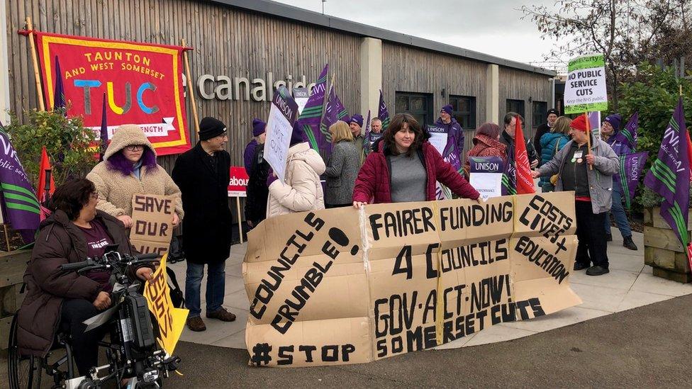 protestors with banners outside a council meeting