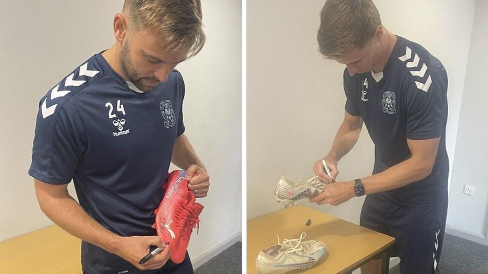 Matty Godden and Ben Sheaf signing their boots