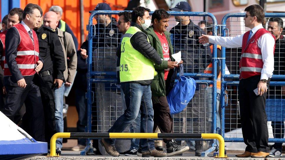 Refugees are escorted by Turkish police as they arrive by ferry from the Greek island of Lesvos (Lesbos) at the Dikili harbour in Izmir, Turkey