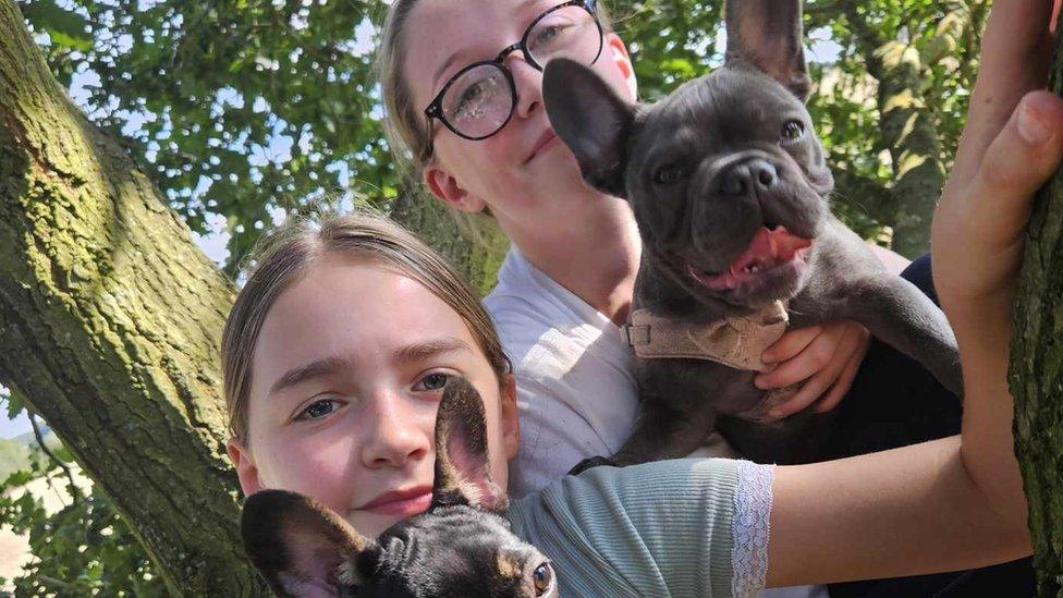 Pippa's daughters Tallulah and Lily holding their dogs