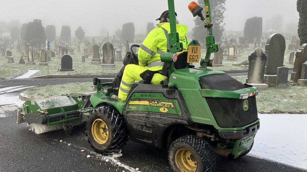 staff on snow sweeper in city cemetery in derry