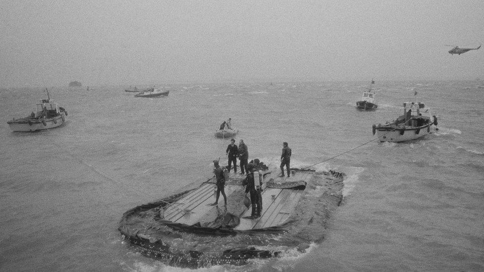 Divers on the upturned hull of hovercraft SR-N6 012