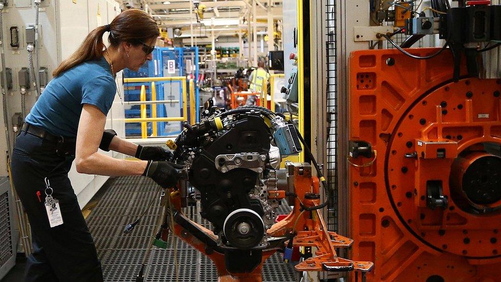 An employee works on an engine production line at a Ford factory