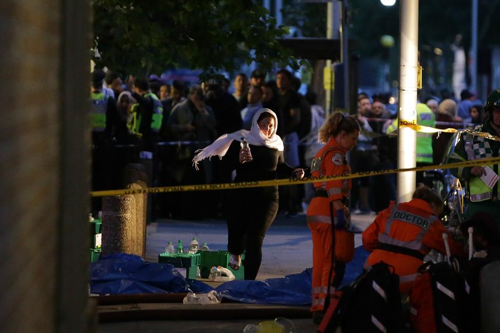 Paramedics, police and crowds of people outside Grenfell Tower