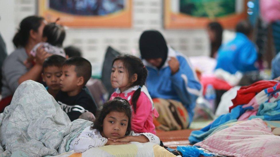 Children lie down at an evacuation centre