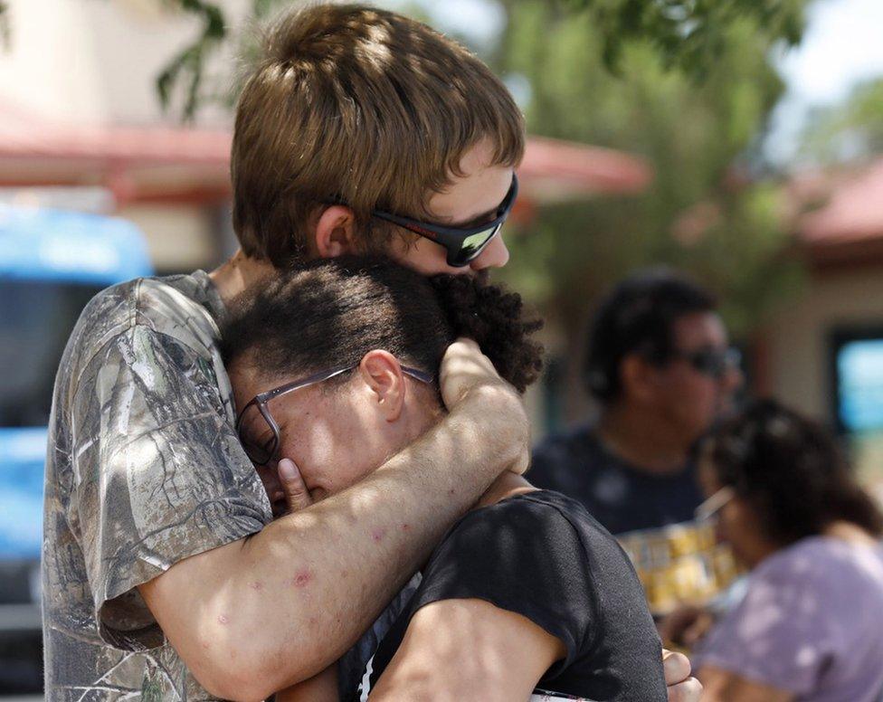 Kianna Long (R) is comforted by a relative