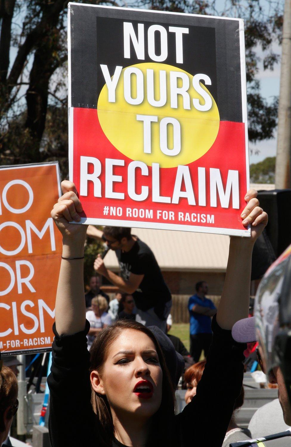 A protester from an anti-racism group holds up a sign