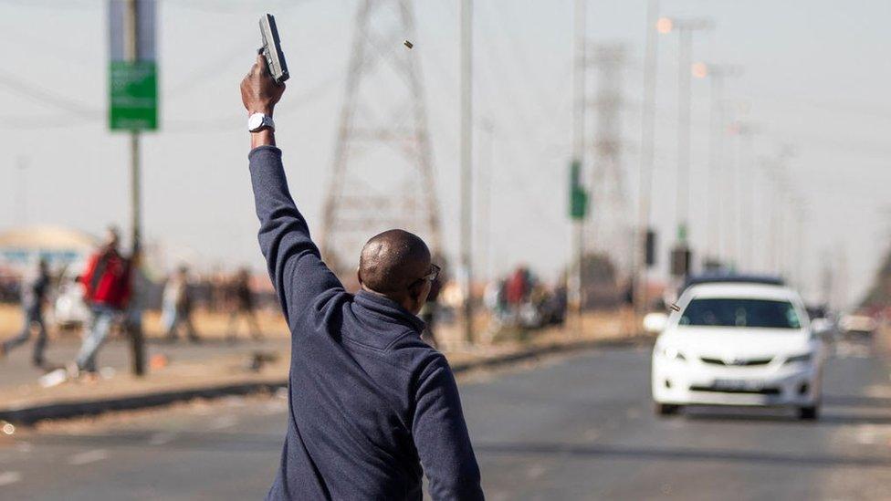 A man holds up a gun in South Africa - 2021