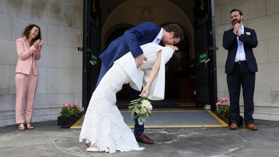 Michael McCaw, from Belfast, and Lucrecia Landeta Garcia, originally from Argentina, with their witnesses Norman Ross (right) and Ruth McNaughton (left) following their wedding ceremony at City Hall in Belfast, as outside weddings with up to six people are currently permitted, to change from Monday to ceremonies permitted outdoors, with no more than 10 people present.