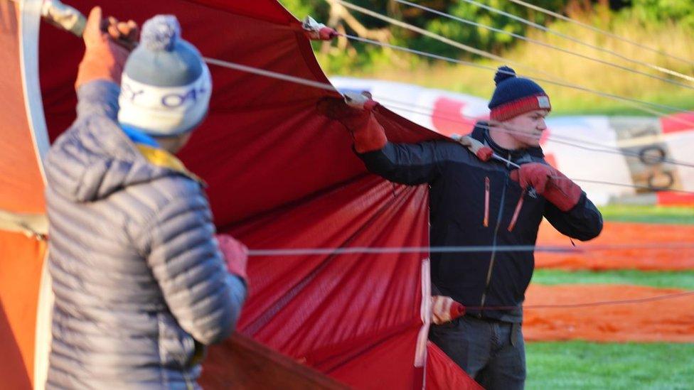 A man inflating a hot air balloon